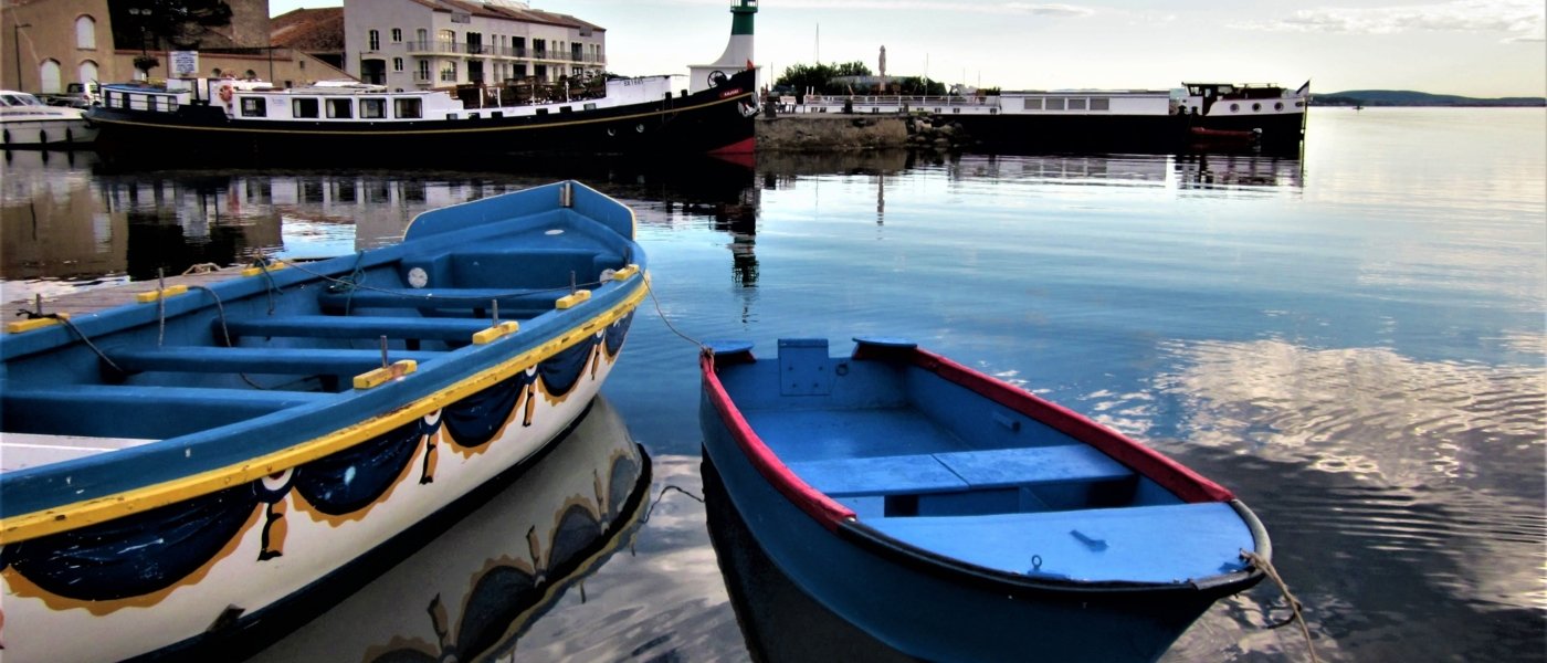 Marseillan ; deux barques et un bateau dans un petit port français ; Le ciel est bleu et l'eau est calme
