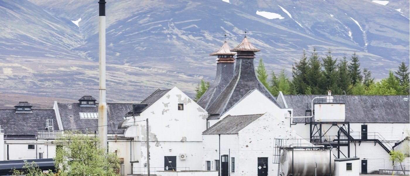 White buildings with grey roof with mountains in the background - Wine Paths